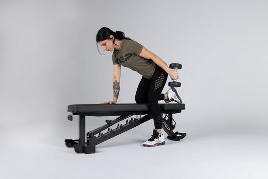 Athlete uses a REP bench to do tricep kickbacks.