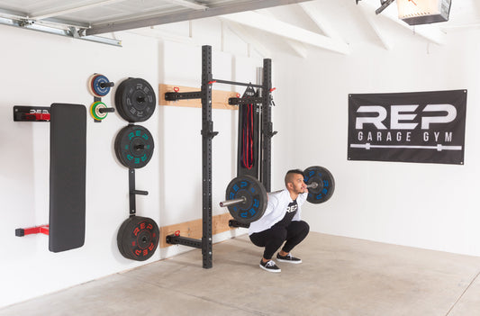 Man doing squats in his garage gym