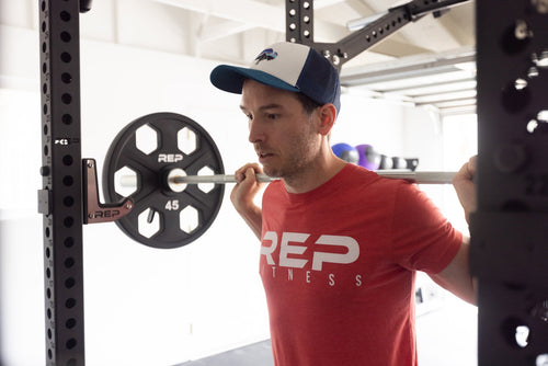 Man doing squats on a power rack