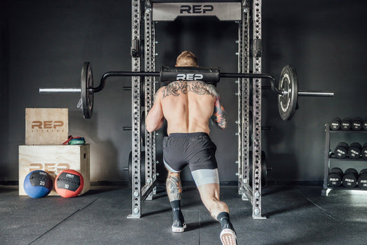 Man doing lunges on a safety squat bar