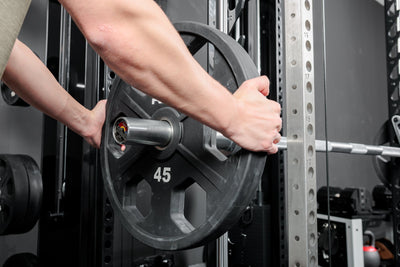 Athlete loading the REP Fitness Altitude™ Power Rack Smith Machine barbell