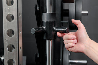 Athlete moving the REP Fitness Altitude™ Power Rack Smith Machine Attachment safeties