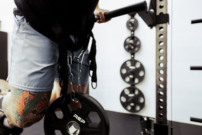 Person using belt squat belt for weighted dips