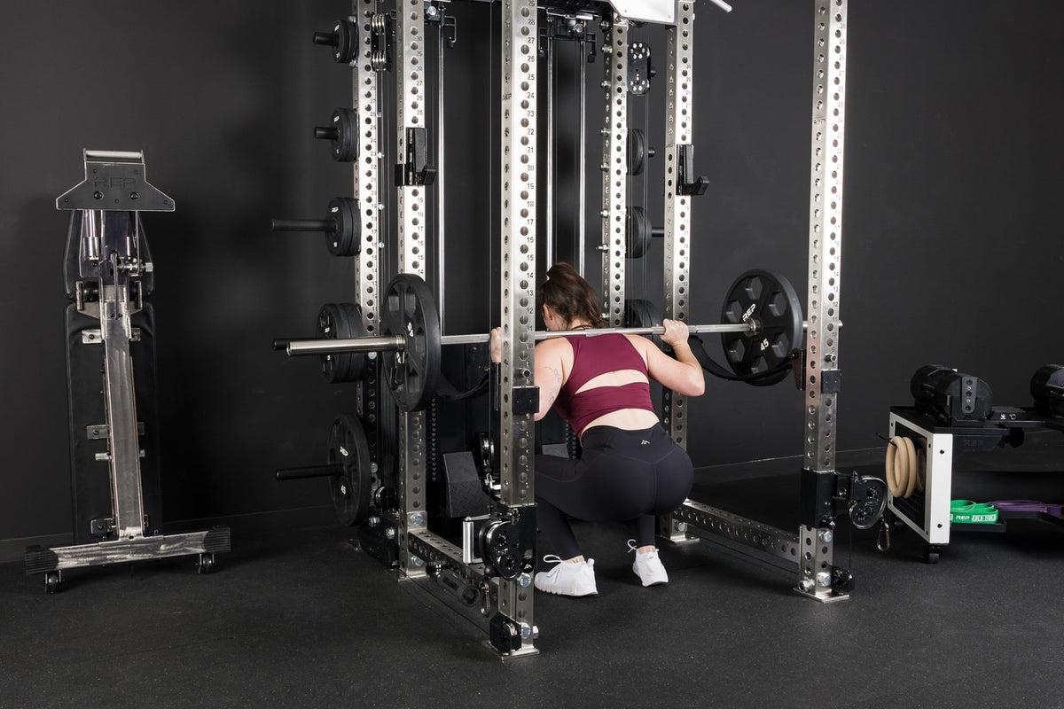 An athlete squatting inside the PR-5000 rack with Equalizer™ Urethane-Coated Plates