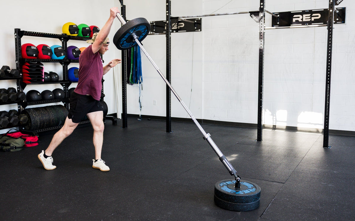 An athlete performing standing presses with the Free Standing REP® x Kleva Built® Adroit Landmine