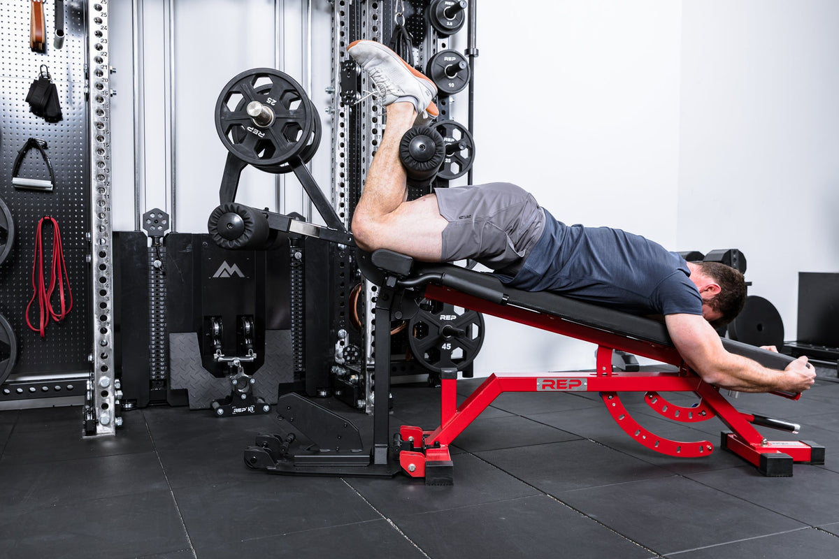 Athlete doing hamstring curls on the Leg Extension & Leg Curl Bench Attachment