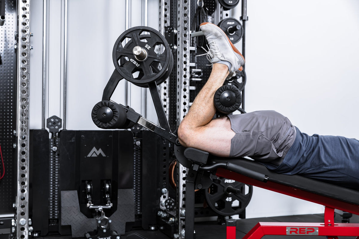 Close up of an athlete doing leg curls on the Leg Extension & Leg Curl Bench Attachment