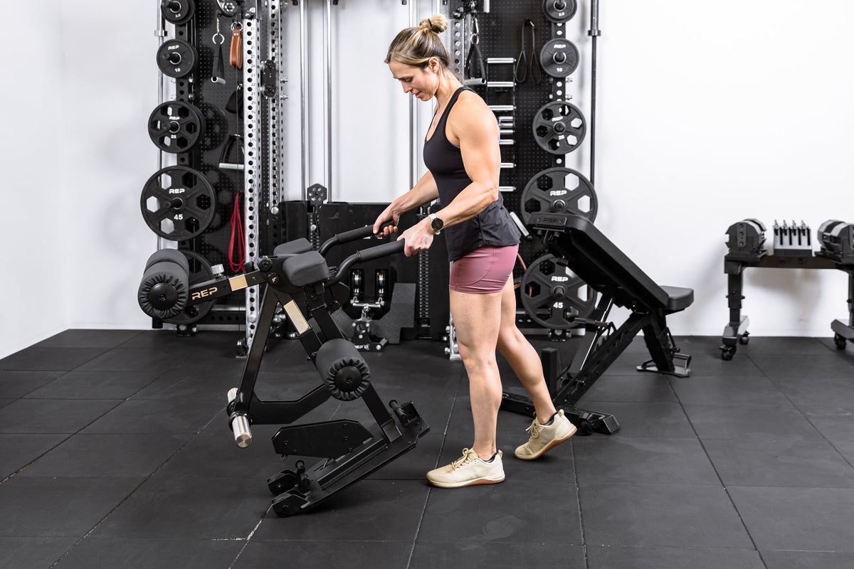 Athlete wheeling the Leg Extension & Leg Curl Bench Attachment