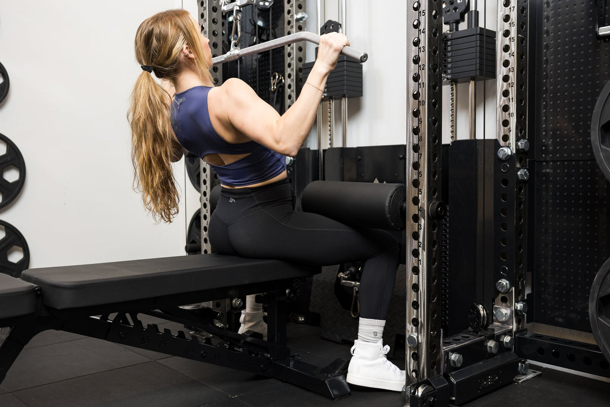 Athlete using the Leg Roller 2.0 as leg restraints for lat pulldowns