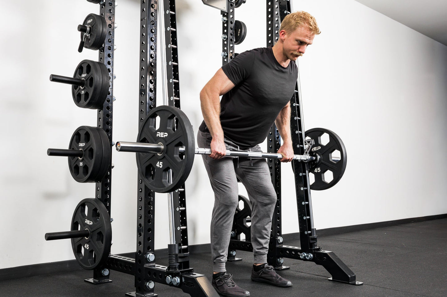 Athlete doing rows on the front of a rack mounted Smith Machine
