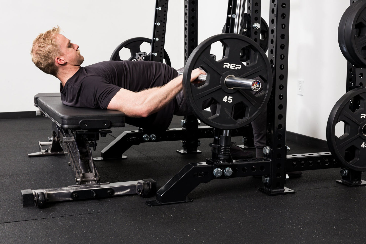 Athlete doing hip thrusters on the front of a rack mounted Smith Machine