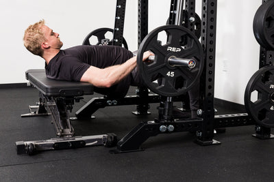 Athlete doing hip thrusters on the front of a rack mounted Smith Machine